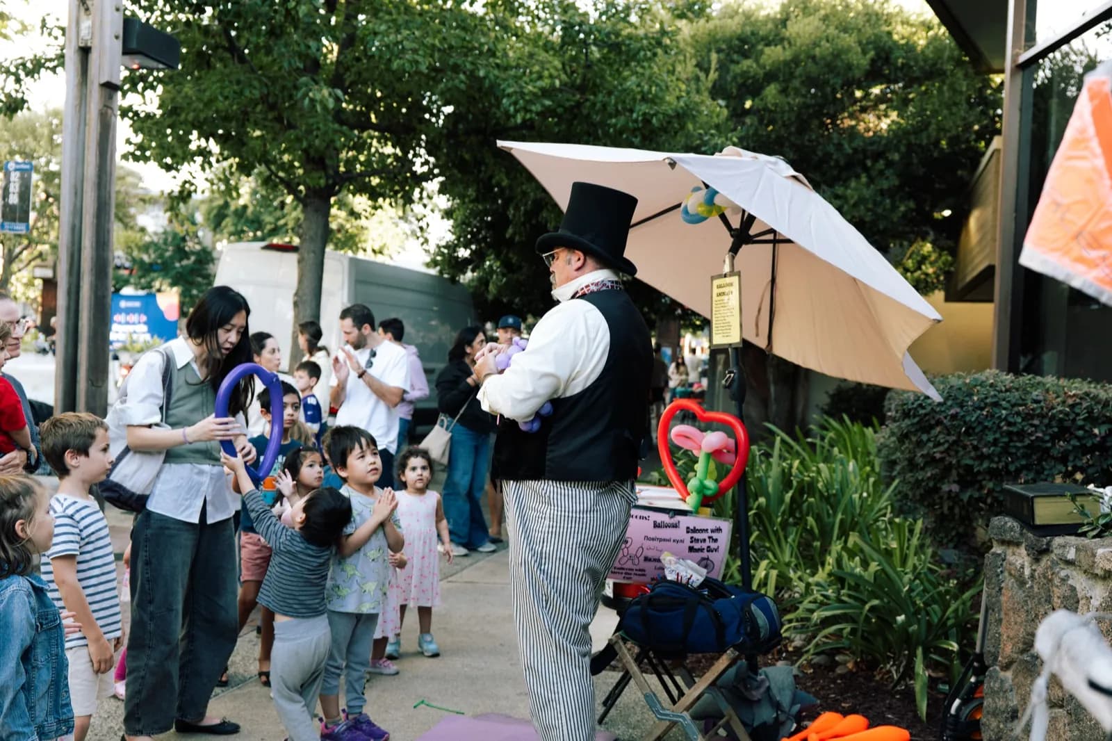 Kids and families gathered around the balloon magician